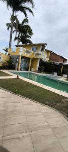 a yellow house with a palm tree and a sidewalk at Casa inigualavel in Caucaia +7 photos