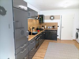 a kitchen with stainless steel appliances and wooden floors at Haus im Grünen l Hot Tub l aktivCARD inklusive in Regen +35 photos