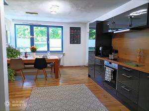 a kitchen with a wooden table and a dining room at Haus im Grünen l Hot Tub l aktivCARD inklusive in Regen