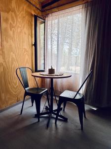 a table and two chairs in a room with a window at Alamos in Puerto Madryn