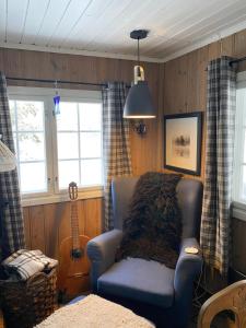 a living room with a chair and a guitar at Golsfjellet in Gol