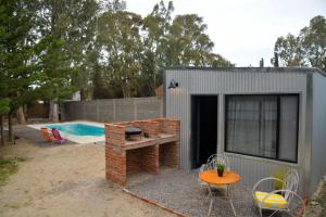 a small shed with a table and chairs next to a pool at Alamos in Puerto Madryn +9 photos