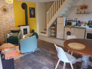 a living room with a table and chairs and a kitchen at Les Girouteaux Le Fenil in Les Eyzies-de-Tayac