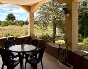 a patio with a table and chairs and a view of a field at Terrarossa in Crispiano