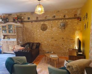 a living room with a couch and a table at Les Girouteaux Le Fenil in Les Eyzies-de-Tayac