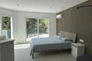 a bedroom with a bed and a large window at Casablanca-Private Family Mountain Home in El Amunt +27 photos