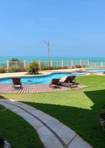 two benches sitting in front of a swimming pool at Apart Canoa Quebrada in Canoa Quebrada