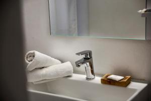 a bathroom sink with a faucet and towels on it at Ghermaniko Guesthouse in Damouchari +48 photos