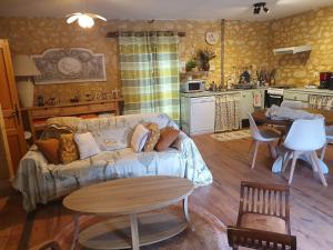 a living room with a couch and a table at Les Girouteaux La bergerie in Les Eyzies-de-Tayac