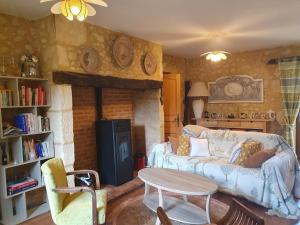 a living room with a couch and a fireplace at Les Girouteaux La bergerie in Les Eyzies-de-Tayac