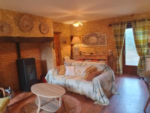 a living room with a bed and a table at Les Girouteaux La bergerie in Les Eyzies-de-Tayac