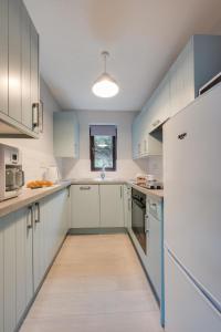 a large kitchen with white cabinets and blue appliances at 3 Bed in Cromer oc-2097 in Cromer