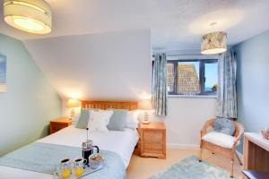 a bedroom with a bed and a table with drinks on it at 3 Bed in Cromer oc-2097 in Cromer