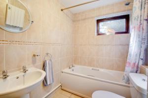 a bathroom with a tub and a sink and a toilet at 3 Bed in Cromer oc-2097 in Cromer +8 photos
