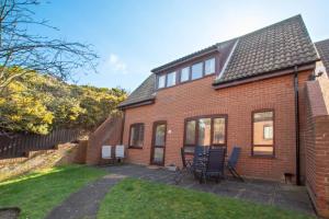a red brick house with chairs in the yard at 3 Bed in Cromer oc-2097 in Cromer