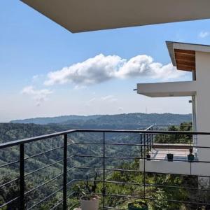 a balcony of a house with a view of the mountains at Stay At Cottages in Pynursla