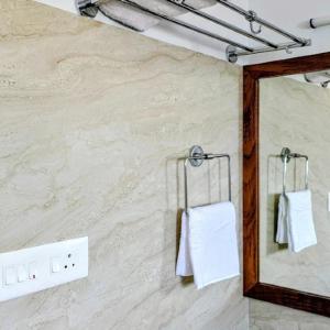 a bathroom with a mirror and towels on a wall at Stay At Cottages in Pynursla +4 photos