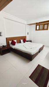 a bedroom with a large bed with red pillows at Hotel Millilium Inn in Gangtok
