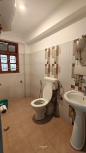 a bathroom with a toilet and a sink at Hotel Millilium Inn in Gangtok