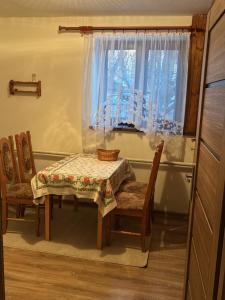 a table and chairs in a kitchen with a window at Privat u Frey in Nová Lesná