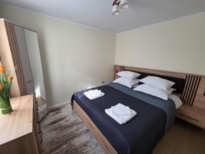 a bedroom with a bed with two towels on it at Căsuța fericită in Techirghiol