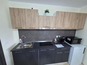 a small kitchen with a sink and a microwave at Căsuța fericită in Techirghiol