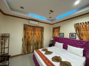 a bedroom with a large bed with a purple headboard at Ruen Thong Resort in Phang-nga +21 photos