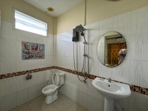 a bathroom with a toilet and a sink and a mirror at Ruen Thong Resort in Phang-nga