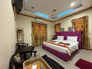 a bedroom with a large bed with a purple headboard at Ruen Thong Resort in Phang-nga