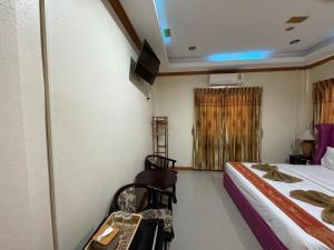 a room with a bed and a desk with a computer at Ruen Thong Resort in Phang-nga