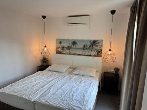 a bedroom with a white bed with two pillows at Casa Bep in Zevenhuizen