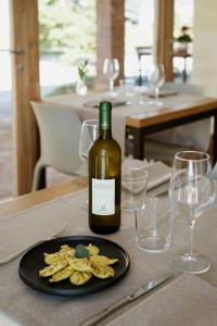 a bottle of wine sitting on a table with a plate of chips at Agriturismo Cà Vida in Ziano Piacentino +10 photos