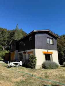 a black and white house with a table and chairs at Casiopea bungalo in San Carlos de Bariloche