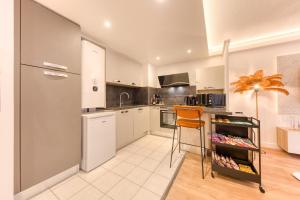 a kitchen with a refrigerator and a chair in it at Premium Spa Suite Jacuzzi Hot Tub Massage Chair near Paris Eiffel Tower-Stade de France-CDG Airport in Drancy