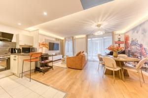 a kitchen and living room with a table and chairs at Premium Spa Suite Jacuzzi Hot Tub Massage Chair near Paris Eiffel Tower-Stade de France-CDG Airport in Drancy +9 photos