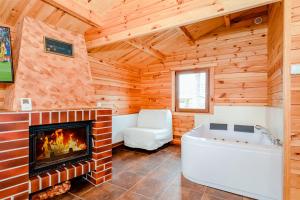 a log cabin living room with a fireplace and a tub at Ferienhaus Ustronie I Nr 1 in Ustronie Morskie