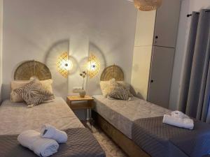 a bedroom with two beds with towels on them at DM Seaside House in Perissa
