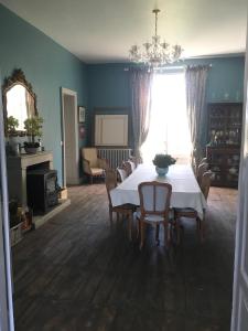 a dining room with a white table and chairs at Château des Fouilloux in Agris
