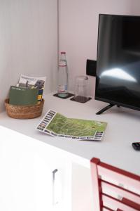 a desk with a computer monitor and a magazine on it at Agriturismo Cà Vida in Ziano Piacentino
