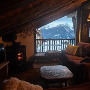 a living room with a view of a snow covered mountain at Chalet Lumière Alpine in La Salle
