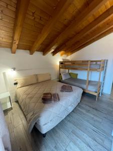 a large bed in a room with a wooden ceiling at Homely - Malpensa & Fiere Milano in Cardano al Campo