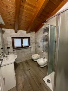 a bathroom with two sinks and a toilet and a shower at Homely - Malpensa & Fiere Milano in Cardano al Campo +31 photos