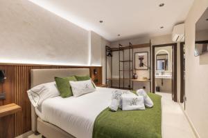 a bedroom with a large white bed with green accents at Amaranta Hotel Boutique in Ronda +45 photos
