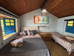 a bedroom with two beds and a couch in it at Saracura in Praia de Araçatiba