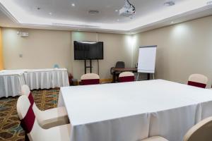 a conference room with a table and chairs and a screen at Vercure Hotel فندق فيركيور جده الحمراء in Jeddah +54 photos