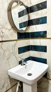 a bathroom with a white sink and a mirror at Hotel Monsoon in Warangal