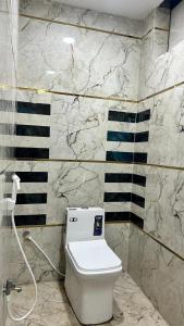 a bathroom with a white toilet and black and white stripes at Hotel Monsoon in Warangal +7 photos