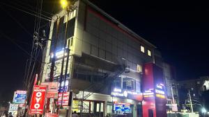 a building with neon signs in a city at night at Hotel Monsoon in Warangal