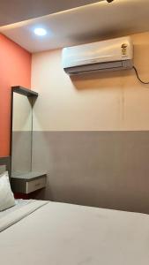 a bedroom with a bed with a air conditioner on the wall at Hotel Monsoon in Warangal