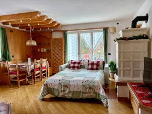 a bedroom with a bed and a dining room at Villa Iris - la prima Villa Vacanze nell'Altopiano in Asiago